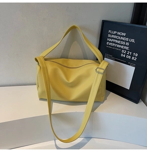 Macro detail of yellow textured leather bag with zipper and adjustable wide shoulder strap