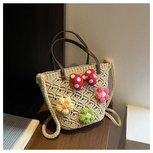 Detail of handmade crochet bucket bag with 3D floral accents and brown leather handle