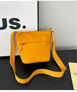Dettaglio borsa a secchiello in nylon giallo senape con zip e tracolla larga regolabile