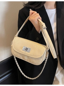 Elegant beige quilted crossbody bag with silver chain strap and metal turn-lock