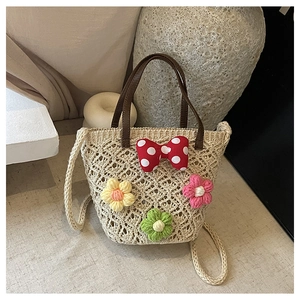 Detailed close-up of handmade hollow woven beach bag with floral and bow decoration