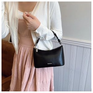 Close-up of a minimalist black crescent bag with silver C&HEKA logo and leather handle