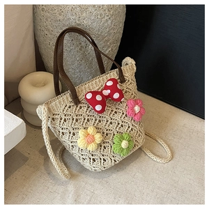 Detailed macro view of handmade crochet flower patterns and polka dot bow on beach bag