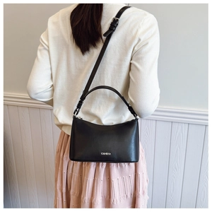 Detailed view of the adjustable metal buckle strap on a black leather crescent bag