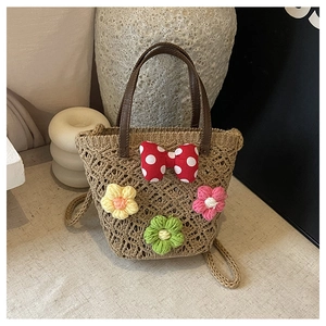 Detailed close-up of woven straw bucket bag with floral crochet and polka dot bow