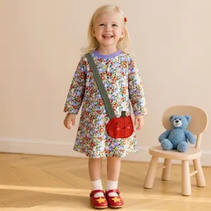 Detail of girls' long-sleeve floral dress with colorful patterns and purple round neck