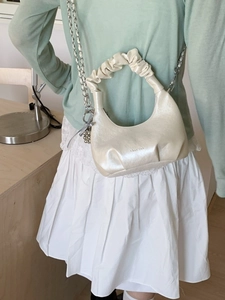 Elegant off-white half-moon pleated cloud bag with silver chain strap and pearl finish