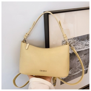 Detail of light yellow PU leather handbag featuring metallic G&HEKA logo and zipper
