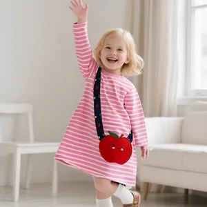 Detail of girls' pink and white striped dress featuring a red apple embroidered pocket