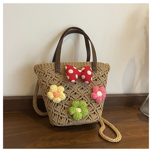 Detail of hand-woven bucket bag with colorful crochet flowers and a red polka dot bow