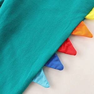 Close-up of blue kids' trousers with colorful dinosaur dorsal fin details and premium knit fabric