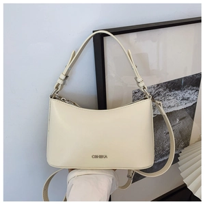 Detail of creamy off-white leather crescent bag with CHHEKA logo and adjustable strap