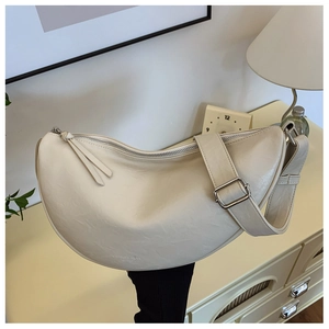 Detailed close-up of beige moon bag showing leather texture and adjustable strap buckle