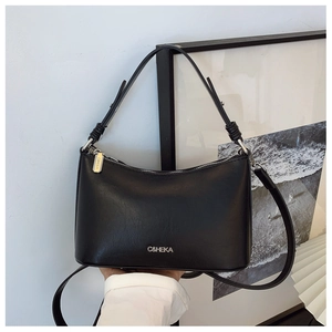 Close-up of a black leather underarm bag featuring an adjustable strap and logo detail