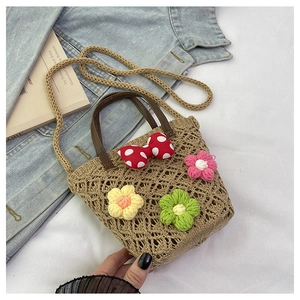 Detailed texture of straw bucket bag with floral crochet and red polka dot bow