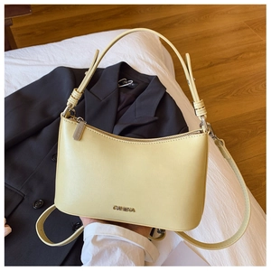 Detail view of cream leather shoulder bag with adjustable strap and metal C&KERA logo branding