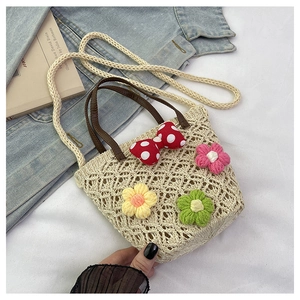 Detailed macro of beige woven straw bucket bag with floral crochet and red polka dot bow