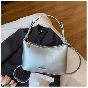 Detail of silver metallic leather dumpling bag with adjustable strap and chic metal logo