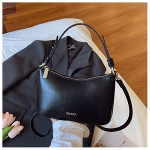 Detail of matte black leather shoulder bag with metallic zipper and adjustable strap