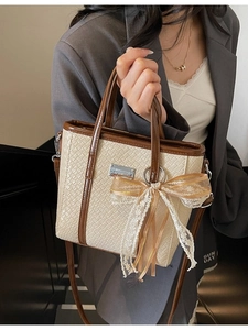 Elegante borsa a secchiello intrecciata beige con finiture in pelle marrone e fiocco