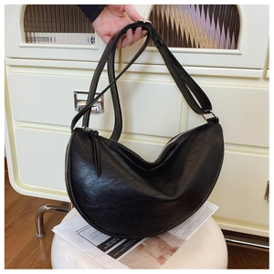 Detailed macro view of black PU leather half-moon bag with adjustable strap and silver zipper