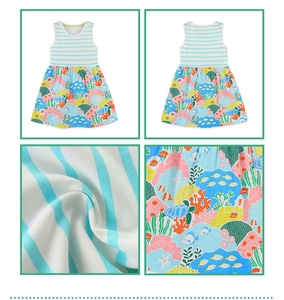 Dettaglio del tessuto a righe bianche e blu e stampa oceanica sull'abito da bambina