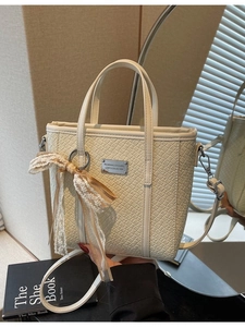 Elegante borsa a secchiello intrecciata crema con tracolla regolabile e ciondolo in pizzo