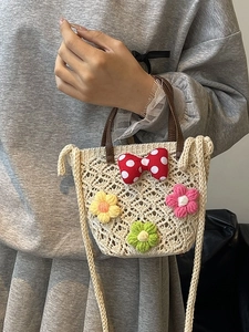 Chic beige crochet beach bucket bag with colorful floral appliques and brown straps