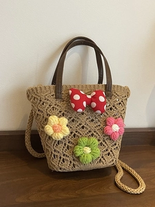 Handwoven bucket bag with leather handles and Minnie-style polka dot bow decoration