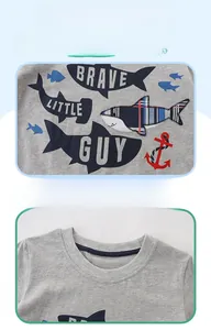 Détail de l'encolure ronde et de l'imprimé requin sur le t-shirt gris en coton pour enfant