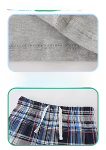 Détail de l'ourlet en tricot gris et taille élastique à carreaux bleus avec cordon