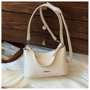 Detail of cream white faux leather shoulder bag with metallic logo on textured silk