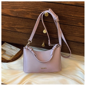 Detail view of lavender vintage crossbody bag with metal logo and adjustable leather strap
