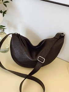 Minimalist black crescent crossbody bag with adjustable strap and vintage texture