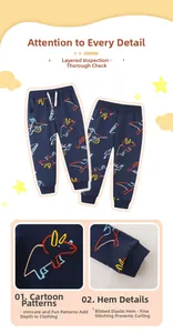 Detail of boys navy blue jogger pants featuring colorful cartoon dinosaur prints and ribbed cuffs