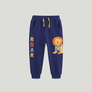 Détail du jogging bleu foncé pour enfant avec cordon jaune et imprimé lion