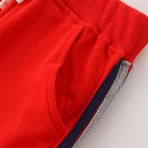 Kids red sports joggers with elastic ribbed waistband and side stripe detail