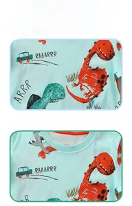 Detailed view of kids mint green cotton T-shirt featuring cute cartoon dinosaur prints