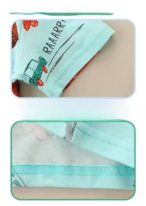 Detail view of double-stitched hem and cuff on a light blue cotton dinosaur t-shirt
