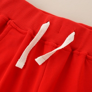 Kids red sports trousers with elastic ribbed waistband and white flat drawstring detail