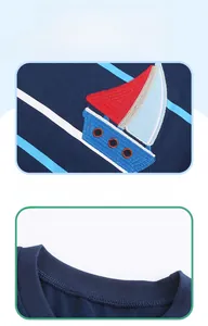 Détail du t-shirt en coton bleu marine avec broderie de voilier et col rond classique