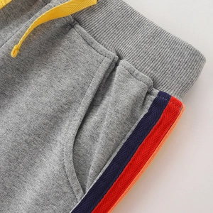 Gray children's sports pants with yellow drawstring and colorful stripe detail on pocket