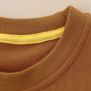 Detail of a dark brown cotton t-shirt with reinforced yellow neck tape and ribbed collar