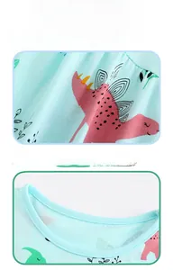 Détail de l'encolure ronde et imprimé dinosaure sur robe en coton tricoté pour filles
