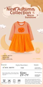 Close-up of bright orange girls' Halloween dress with mesh tutu and pumpkin detail