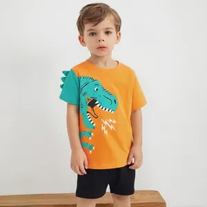Dettaglio maglietta arancione bambino con dinosauro e pantaloncini neri casual in cotone