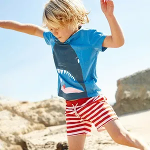 Dettaglio maglietta con squalo e pantaloncini a righe per bambini per mare e estate