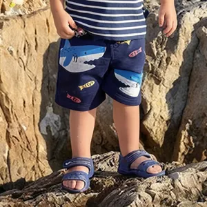 Dettaglio dei pantaloncini blu navy da bambino con stampa di squali e vita elasticizzata