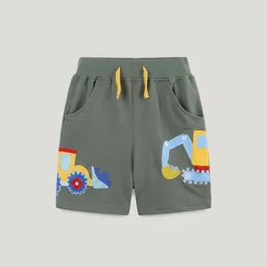 Dettaglio dei pantaloncini estivi da bambino in cotone verde oliva con stampe di escavatori