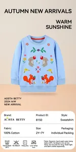 Close-up of intricate rabbit and squirrel floral embroidery on a blue cotton kids sweatshirt
